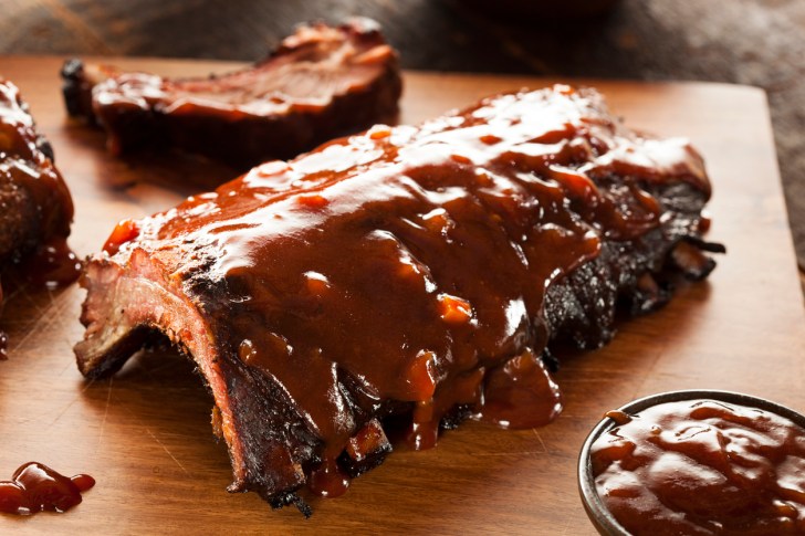A close-up of smoked barbecue pork spare ribs on wood
