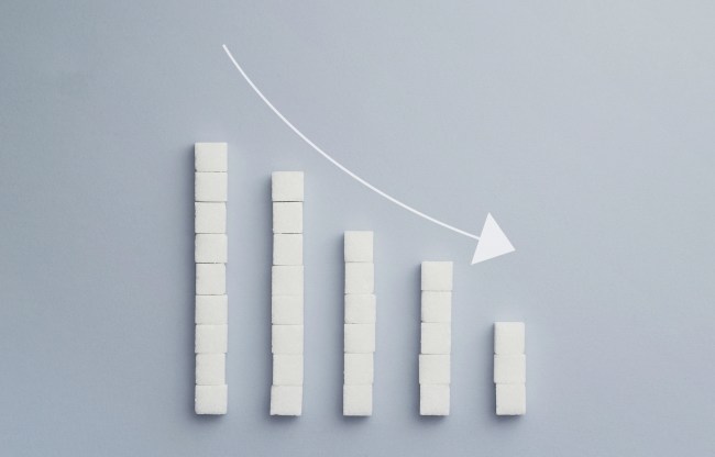 Concept: Negative graph chart made of sugar cubes with an decrease arrow