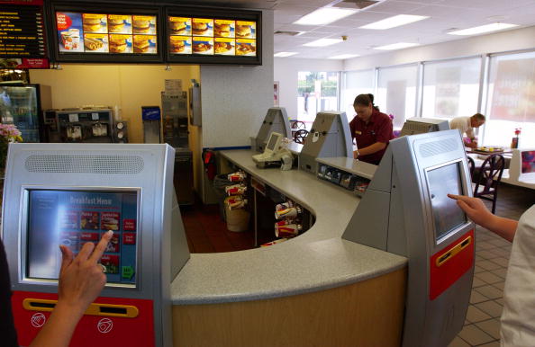 DENVER - JULY 18: Customers at a McDonald's store place orders and pay through a new kiosk system being tested in five Denver area stores July 18, 2003 in Littleton, Colorado. McDonald's hopes the self-service system will speed customer service, help limit lines and making dining at the restaurants easier. The company plans to test the system in a dozen stores in Raleigh, N.C. (Photo by Kevin Moloney/Getty Images)