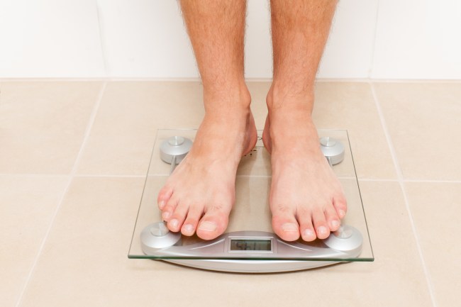 foot of man standing on bathroom scale