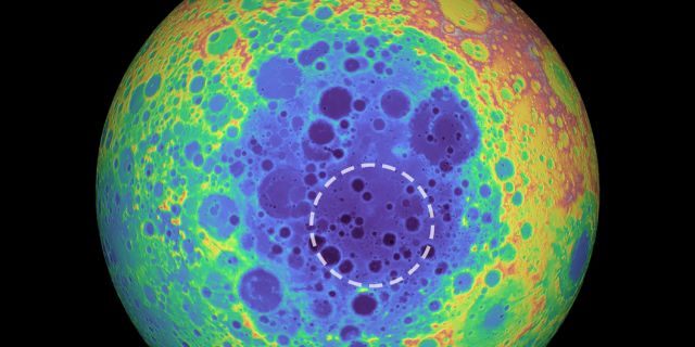 This false-color graphic shows the topography of the far side of the Moon. The warmer colors indicate high topography and the bluer colors indicate low topography. The South Pole-Aitken (SPA) basin is shown by the shades of blue. The dashed circle shows the location of the mass anomaly under the basin. 