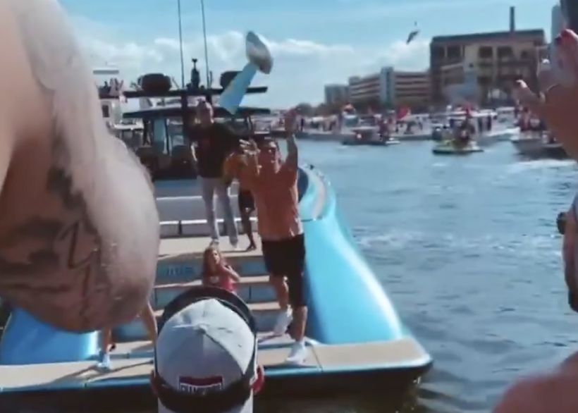 brady throws lombardi trophy to boat