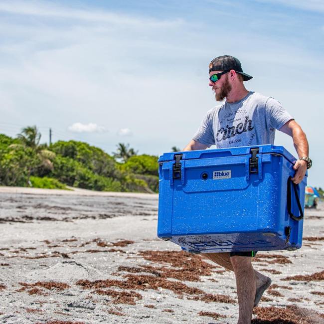 Best coolers for the money, featuring a man holding a cooler on a beach
