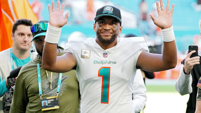 tua tagovailoa waving to fans in a dolphins jersey