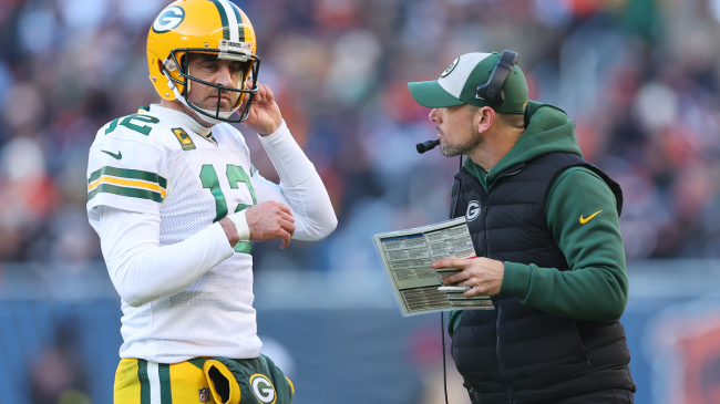 Aaron Rodgers discusses a play with his head coach.