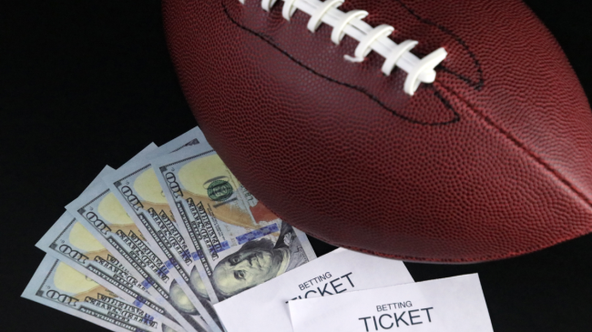 A football rests beside sports betting tickets.