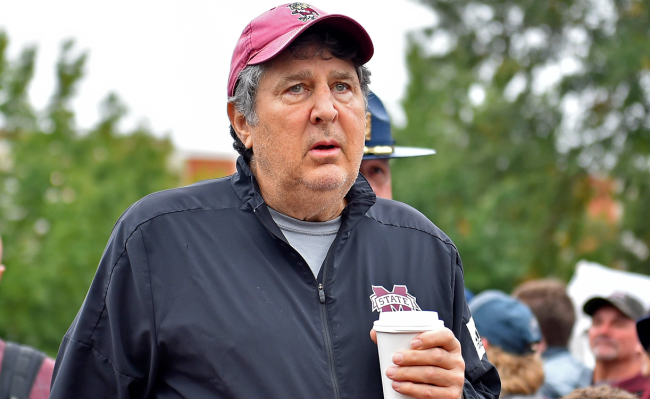 mike leach walks with a cup of coffee