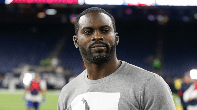 Michael Vick watches a game from the sidelines.
