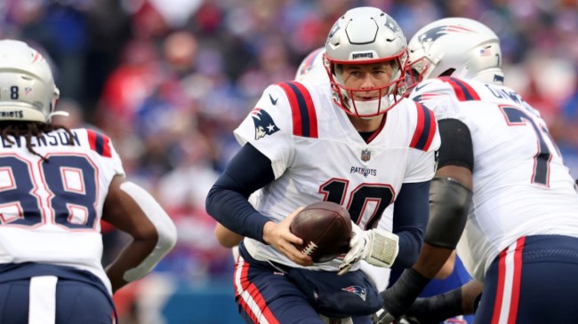 New England Patriots quarterback Mac Jones handing the ball off