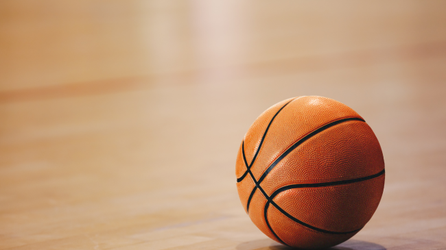 A basketball rests on the court.