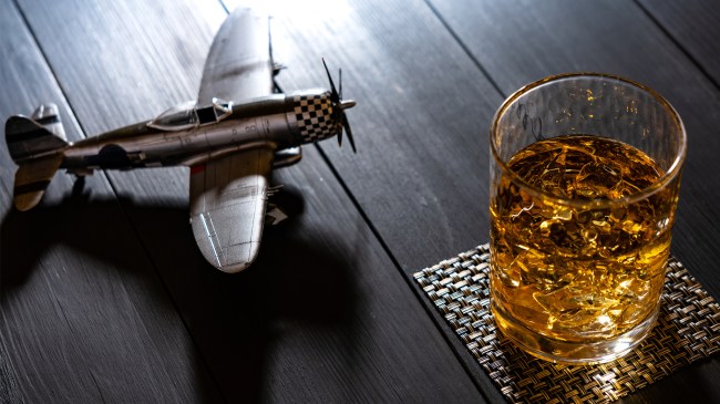 a model airplane next to a glass of whiskey