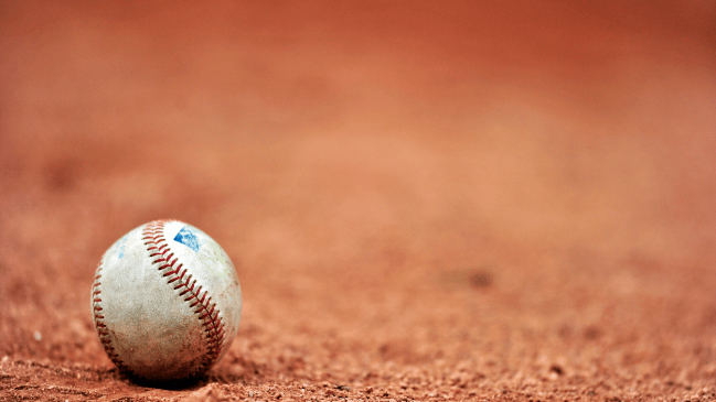 A baseball sits on the clay.