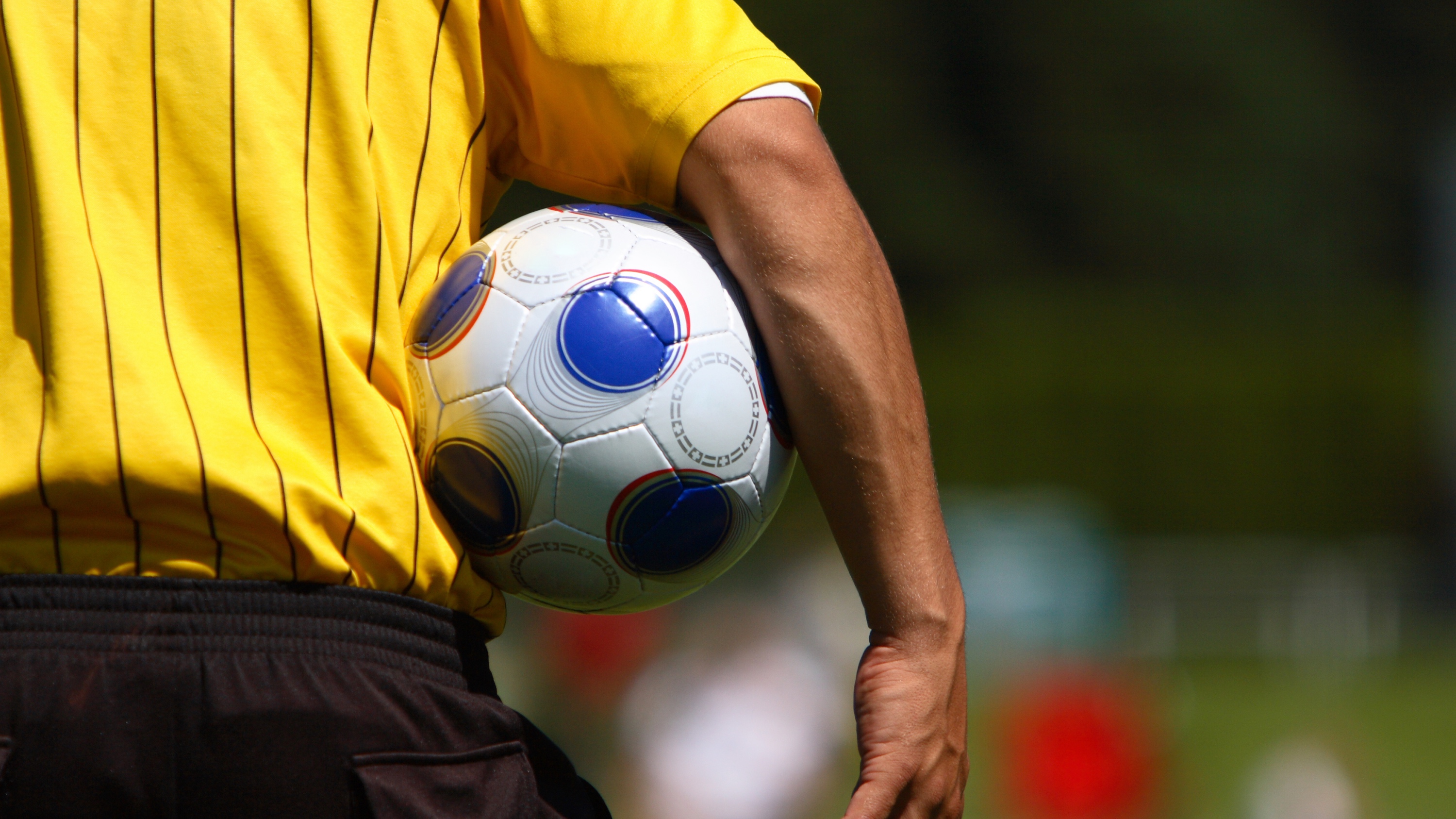 soccer referee holding a soccer ball