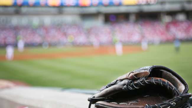 A view of a baseball mitt and a crowd in the background.