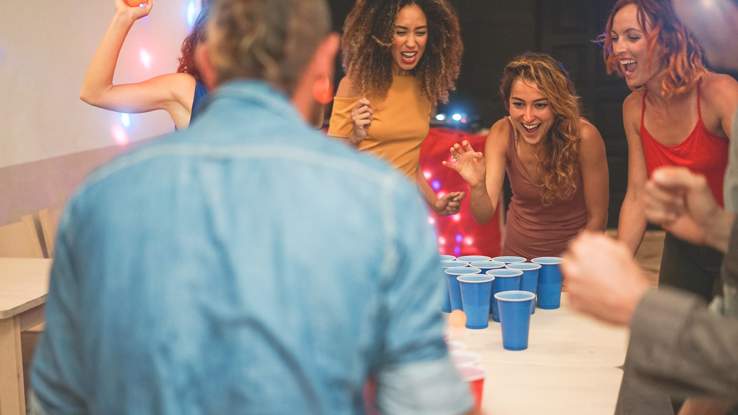 women playing beer pong and drinking
