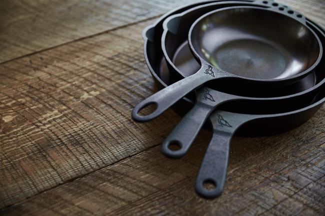 Smithey Ironware cast iron skillets on a wood counter.