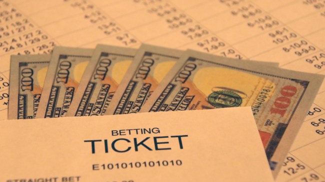 A betting ticket lays beside $100 bills.