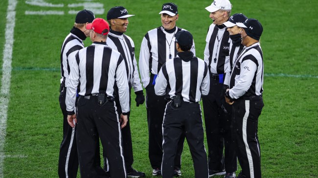 A group of XFL referees discuss a call.
