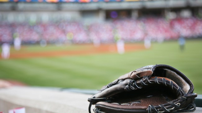 A baseball fan's glove rests atop the stadium wall.