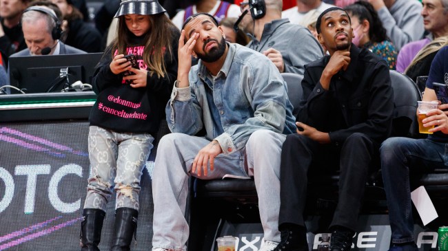 Drake watches courtside at an NBA game.