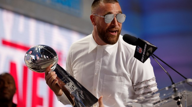 Travis Kelce holds the Lombardi Trophy at a Chiefs Super Bowl celebration.