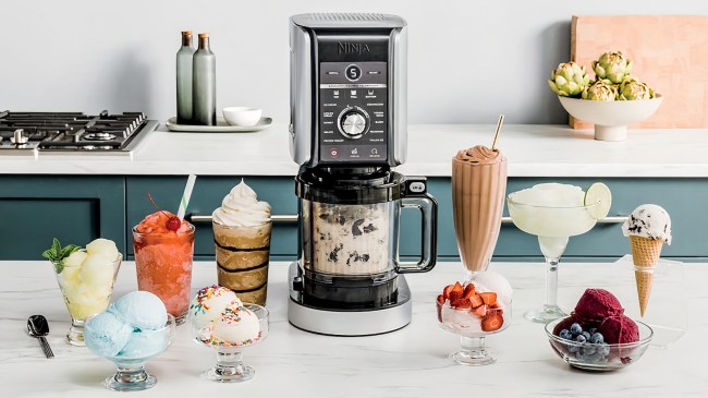 Ninja CREAMi Ice Cream maker on a kitchen counter, surrounded by ice cream