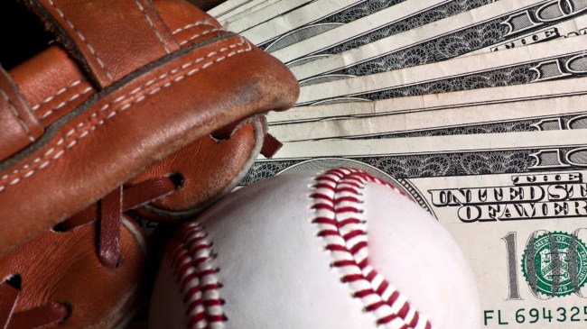 A baseball and mitt lay on a stack of money.