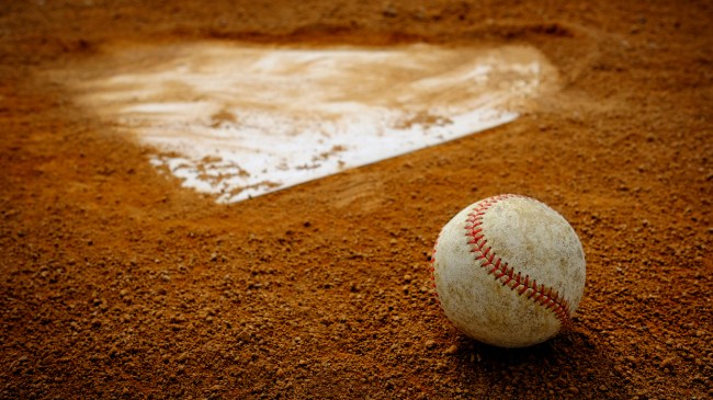 A baseball sits behind home plate.