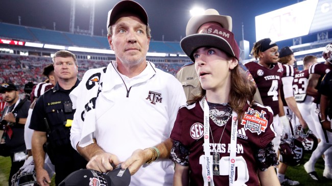 Jimbo Fisher walks off the field with his son, Ethan, after a bowl game.