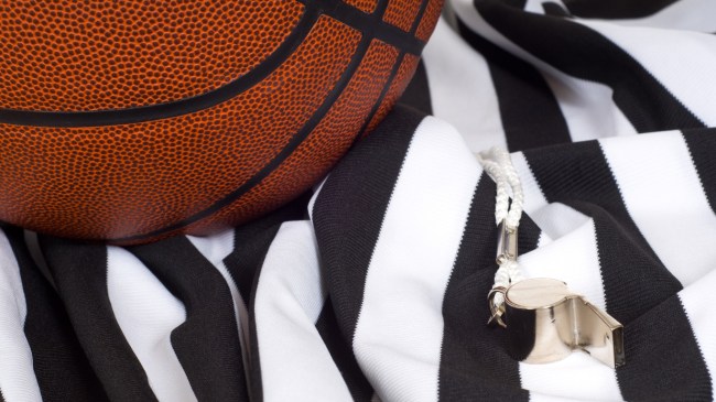A basketball lays on top of a referee's jersey.
