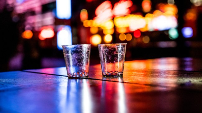 An image of empty shot glasses on a bar.
