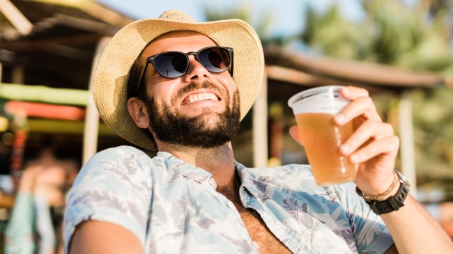 Man drinking beer while getting a tan
