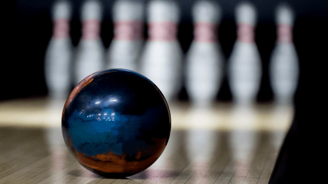 A bowling ball rolls down the lane.