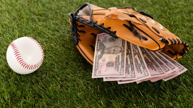 A baseball sits beside a glove full of money.