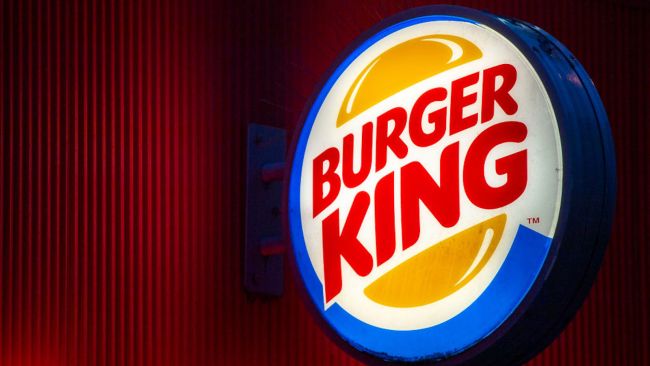 burger king logo in front of a red wall