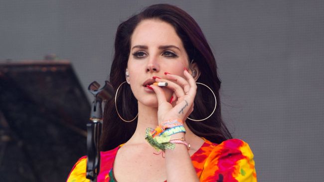 lana del rey smoking a cigarette on stage