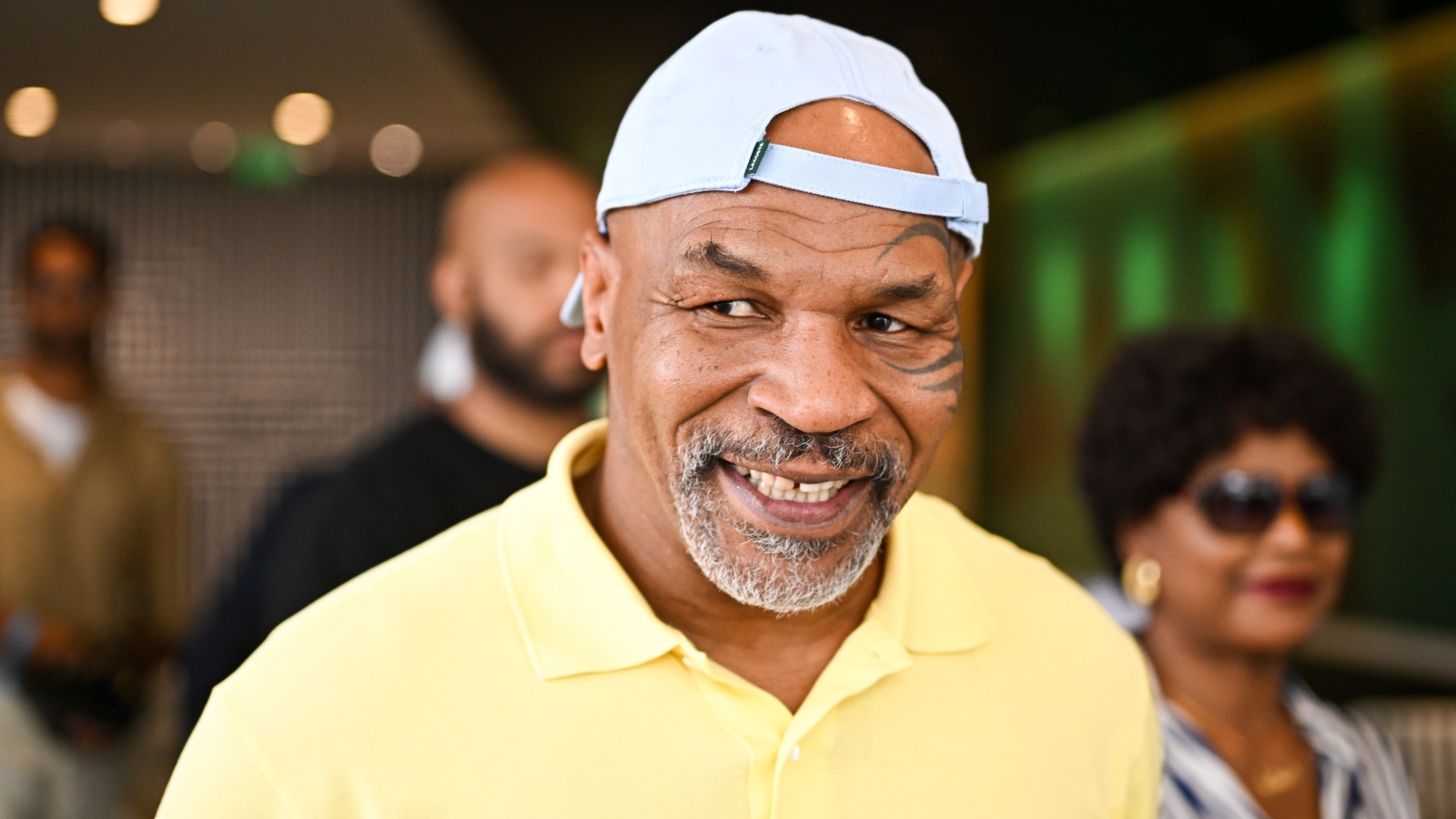 Mike Tyson smiling in a yellow shirt