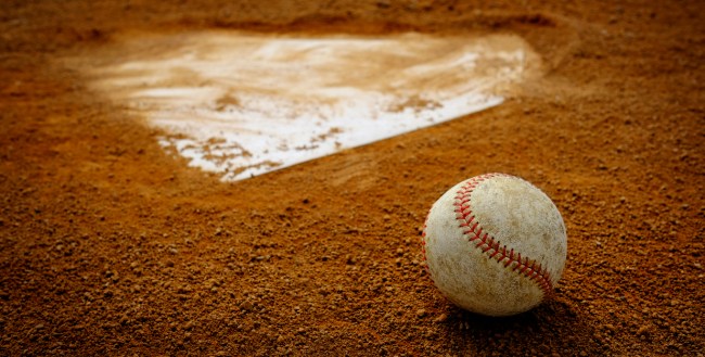 A baseball rests behind home plate.