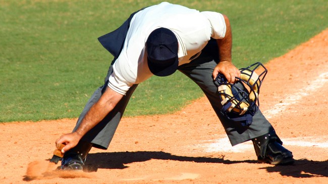 Baseball umpire cleaning home plate