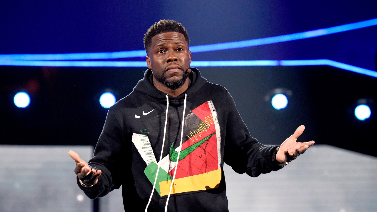 Kevin Hart with his hands up shrugging