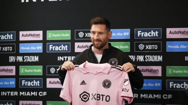 lionel messi holding an inter miami shirt