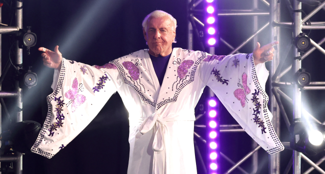 ric flair salutes the crowd in his robe