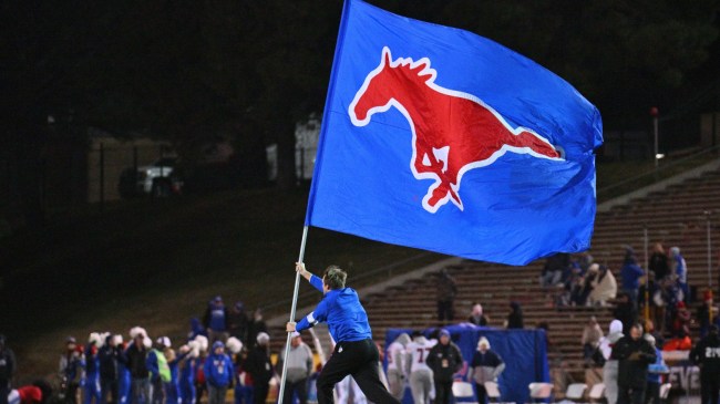 An SMU cheerleader runs with a Mustangs flag during a game vs. BYU.