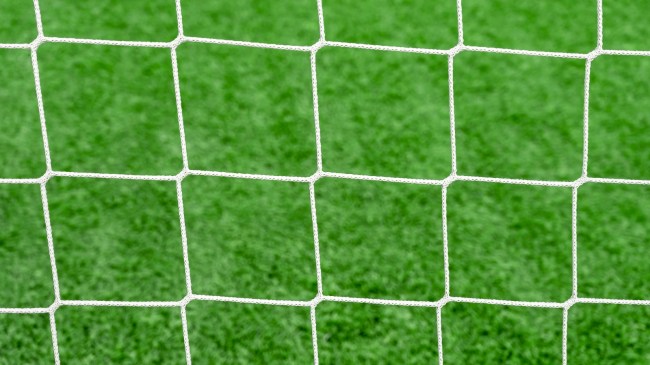 A view of a soccer field from behind the net.