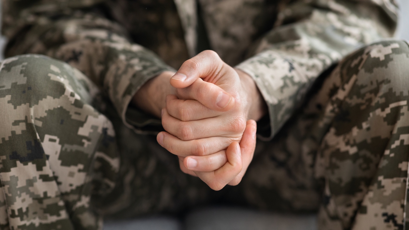 soldier waiting with folded hands before surprising family