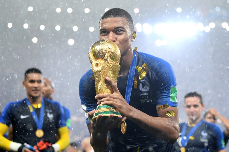 Kylian Mbappe kissing World Cup trophy