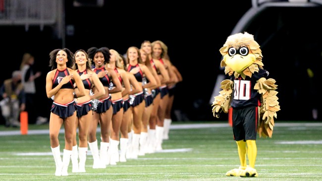 The Atlanta Falcons mascot comes onto the field alongside cheerleaders.