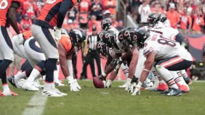 Players from the Chicago Bears and Denver Broncos line up at the line of scrimmage.