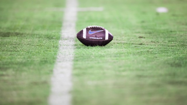 A ball rests on the field during a college football game.