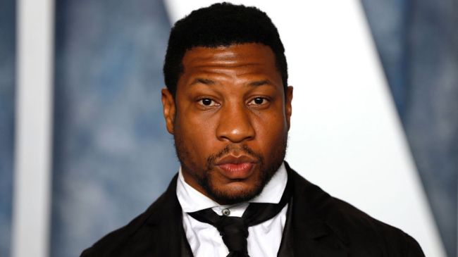 jonathan majors in a black suit